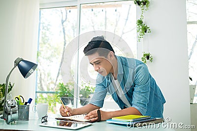 Portrait of handsome asian young writing something on notebook a Stock Photo