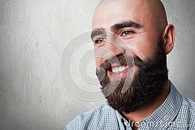 A portrait of handsome bald man with thick beard and mustache having sincere smile while posing against white background. A fashio Stock Photo