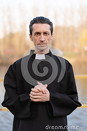 Portrait of handsome catholic priest or pastor with collar Stock Photo