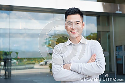 Portrait of an handsome confident asian man outside buidling. Stock Photo