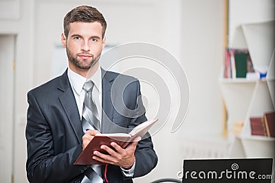 Portrait of handsome confident businessman writing Stock Photo