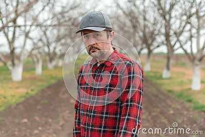 Portrait of handsome confident farmer in walnut fruit orchard looking at camera Stock Photo