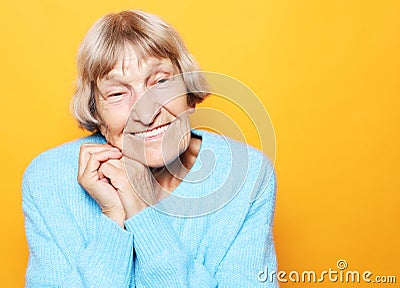 Portrait of handsome grandmother in blue sweater. Dreaming, wondering concept Stock Photo