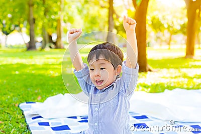 Portrait handsome little boy. Attractive handsome preschool or toddler boy act like a getting victory or win by raise arms up. Cut Stock Photo