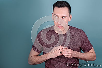 Portrait of handsome man on a dark who tries to remove an engagement ring from his finger. concept of infidelity Stock Photo