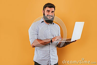 Portrait of handsome smiling man isolated on yellow studio background posing to the camera and making funny faces, got idea, point Stock Photo