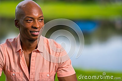 Portrait handsome young black man posing in a park setting. pleasing bokeh lake scene in the background Stock Photo
