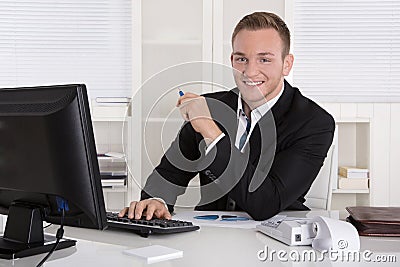 Portrait: Handsome young businessman in suit sitting smiling in Stock Photo