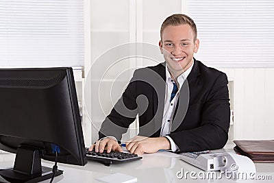 Portrait: Handsome young businessman in suit sitting smiling in Stock Photo