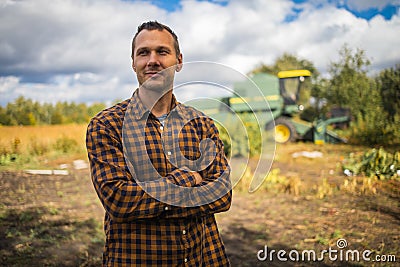 Portrait of young Caucasian handsome happy man farmer standing in field and smiling to camera. Stock Photo