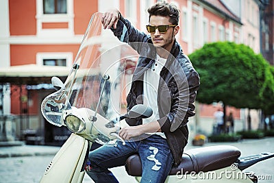 Portrait of a handsome young man on scooter Stock Photo