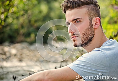 Portrait of handsome young man in white t-shirt in nature Stock Photo