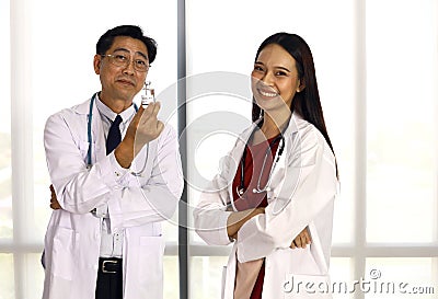 Happiness doctor teamwork holding corona virus vaccine for use in clinic or hospital room. Stock Photo