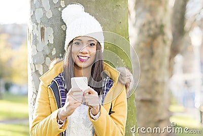 Portrait of happiness woman with hat holding phone, outdoor. Stock Photo