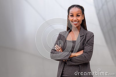 Portrait of a happy African American female company leader, CEO, boss, executive, standing in front of company building, copy spac Stock Photo