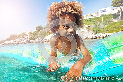 Happy African boy relaxing on swimming mattress Stock Photo