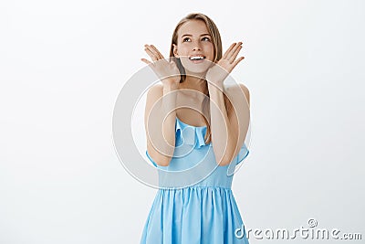 Portrait of happy amused girl realising dream come true feeling upbeat and thankful looking up as holding palms near Stock Photo