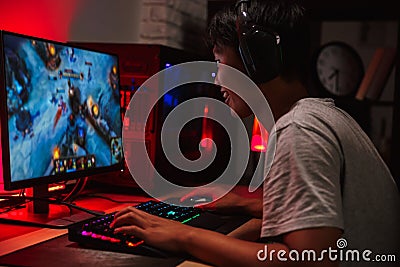 Portrait of happy asian teenage gamer boy playing video games on Stock Photo