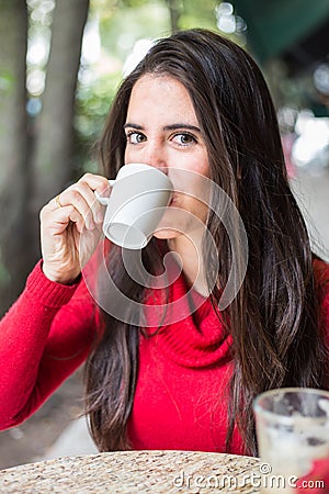 Portrait of happy beautiful brunette with mug in hand and drinking coffee Stock Photo