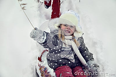 Portrait of happy blondy child in winter park playing in snow Stock Photo