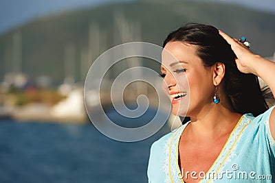 Portrait of a happy brunette woman near the yacht marine Stock Photo
