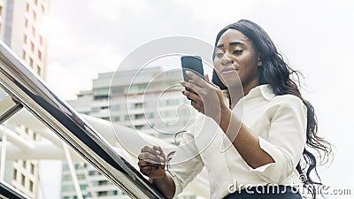 Portrait of happy business african woman uses smartphone Stock Photo