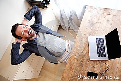 Happy businessman relaxing in office with laptop Stock Photo