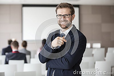 Portrait of happy businessman standing in seminar hall Stock Photo