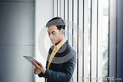 Portrait of Happy Businessman Standing by the Window in Office. Stock Photo