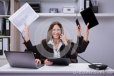 Businesswoman Doing Multitasking Work In Office Stock Photo