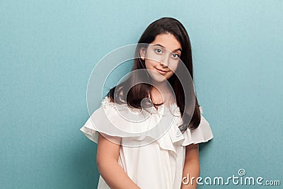 Portrait of happy calm beautiful brunette young girl with black long straight hair in white dress standing and looking at camera Stock Photo