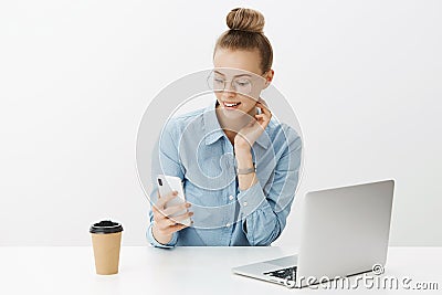 Portrait of happy charming female entrepreneur living digital nomad life scrolling online app in smartphone looking at Stock Photo