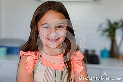 Portrait of happy, dirty with dough caucasian girl baking in kitchen Stock Photo