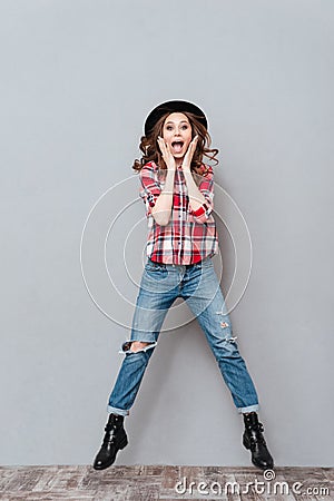 Portrait of a happy excited woman in plaid shirt jumping Stock Photo