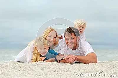 Portrait Of Happy Family of Four People Relaxing on the Beach Stock Photo