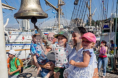 Portrait of happy family near by ship bell of sailboat `Pallada` Editorial Stock Photo