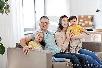 Portrait of happy family sitting on sofa at home Stock Photo