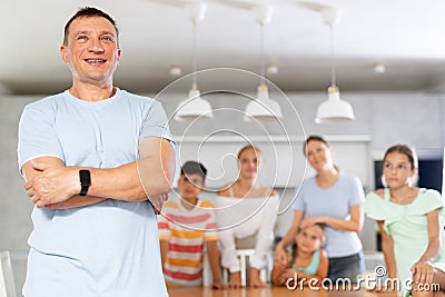 Portrait of happy father of large family against the background of children and his wife in interior of his house Stock Photo