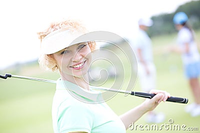 Portrait of happy female golfer holding golf club Stock Photo