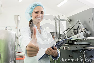 Portrait of happy woman manufacturing specialist showing thumbs up Stock Photo