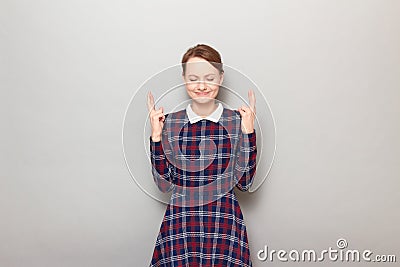 Portrait of happy girl raising crossed fingers and hoping for victory Stock Photo