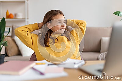 Portrait of happy girl sitting at a table with a laptop Stock Photo