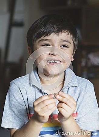 Portrait happy kid looking out with smiling face, Child playing alone in living room, Candid shot cute young boy relaxing stay at Stock Photo