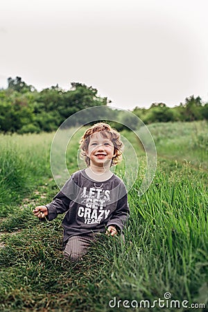 Portrait of a happy little boy in the park. Cute playfull boy Stock Photo