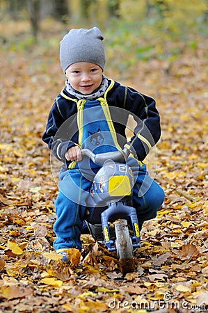 Portrait of a happy little boy riding his motorbike Stock Photo