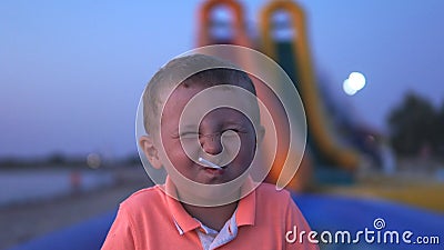 Portrait of happy little boy squinting with candy in mouth Stock Photo