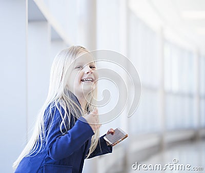 Portrait of happy little girl with smartphone looking at camera Stock Photo