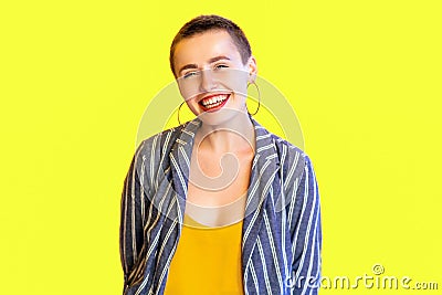 Portrait of happy lively young short hair beautiful hipster woman in yellow shirt and striped suit standing and looking at camera Stock Photo