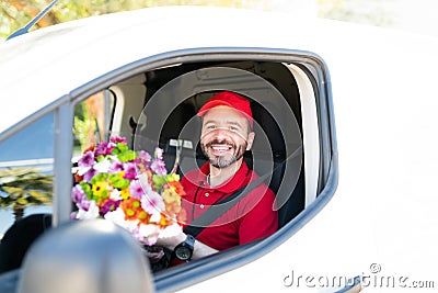 Portrait of a happy male courier holding a bouquet of flowers Stock Photo