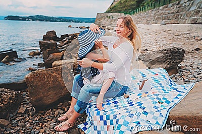 Portrait of happy mother and daughter spending time together on the beach on summer vacation. Happy family traveling, cozy mood. Stock Photo